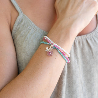 Close-up of a wrist wearing a colorful bracelet with a neutral background